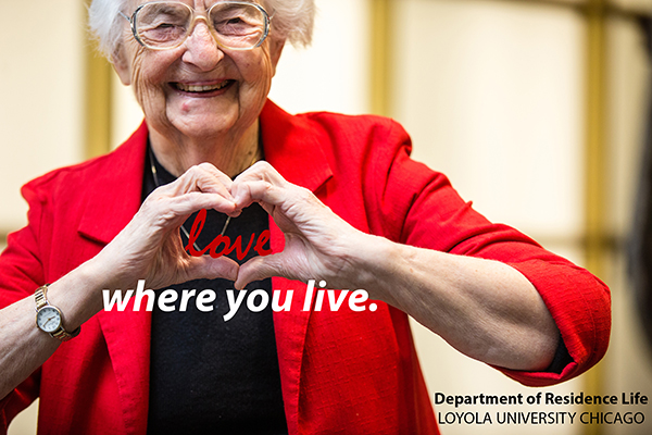 Older woman in red jacket making the heart sign using both her hands while smiling. The word Love in red is between the heart she is making and the words 